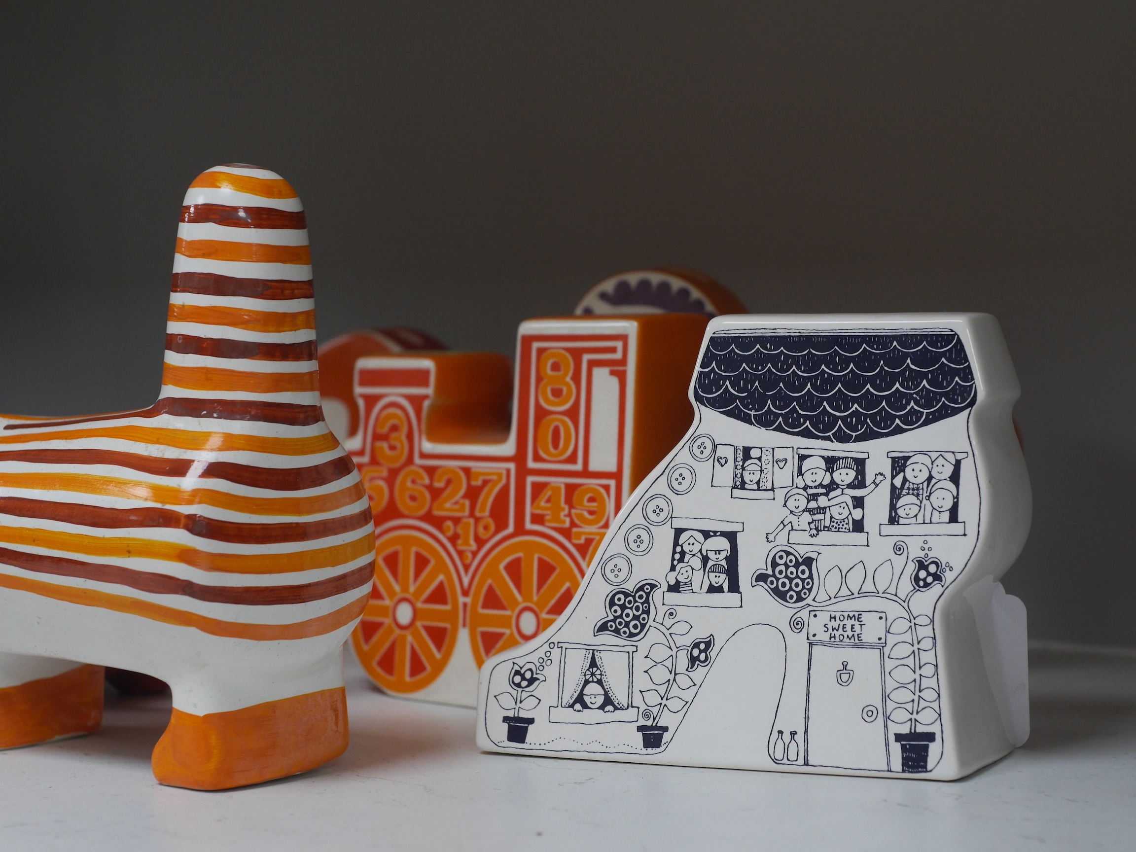 Seven mostly Carlton Ware 1960’s-1970’s money boxes to include examples in the form of a snail, train and two cats, largest 20cm wide. Condition - mostly fair to good